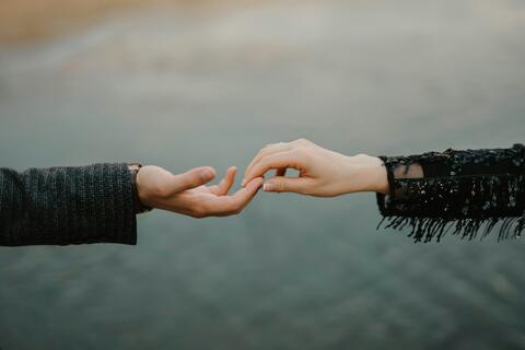 Two hands reaching out to each other.